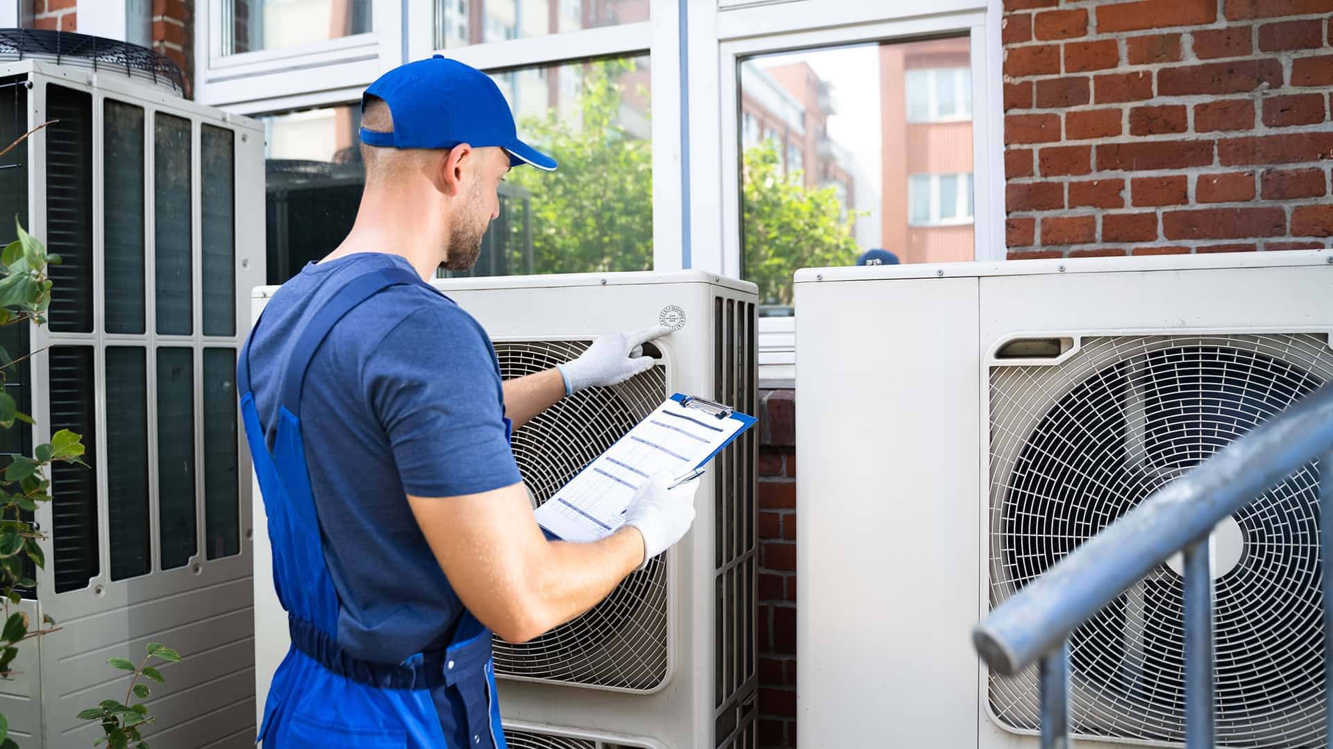 repairman fixing air conditioner unit