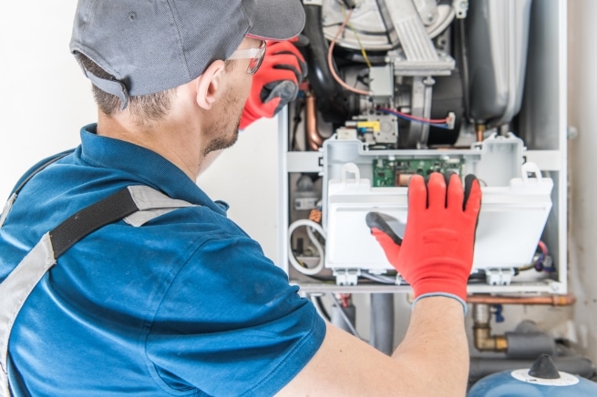 An HVAC technician repairing a home system