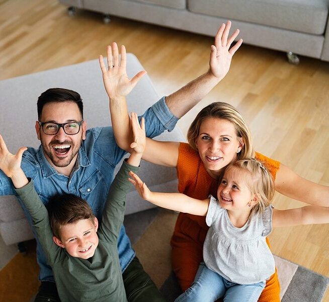 A family of four enjoying home living room space