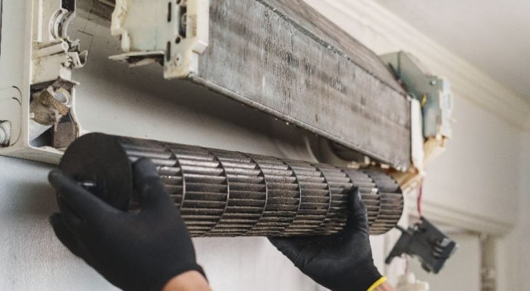 A worn down air conditioning unit in thorough need of replacement.