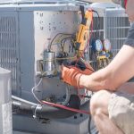 AC technician working on an outdoor air conditioning unit, in the bright sunny skies of Las Vegas.