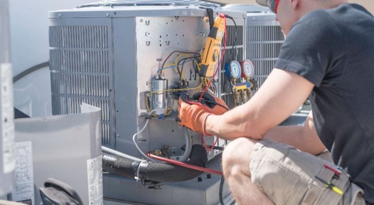 AC technician working on an outdoor air conditioning unit, in the bright sunny skies of Las Vegas.