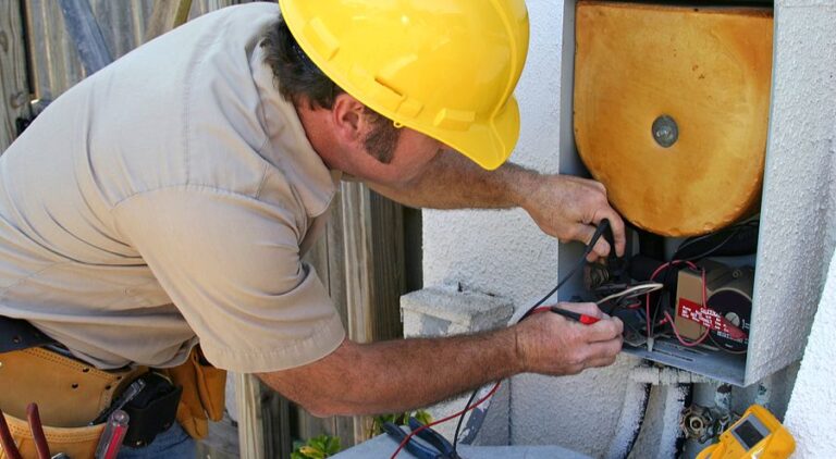 An AC repairman helps maintain an air conditioning unit.